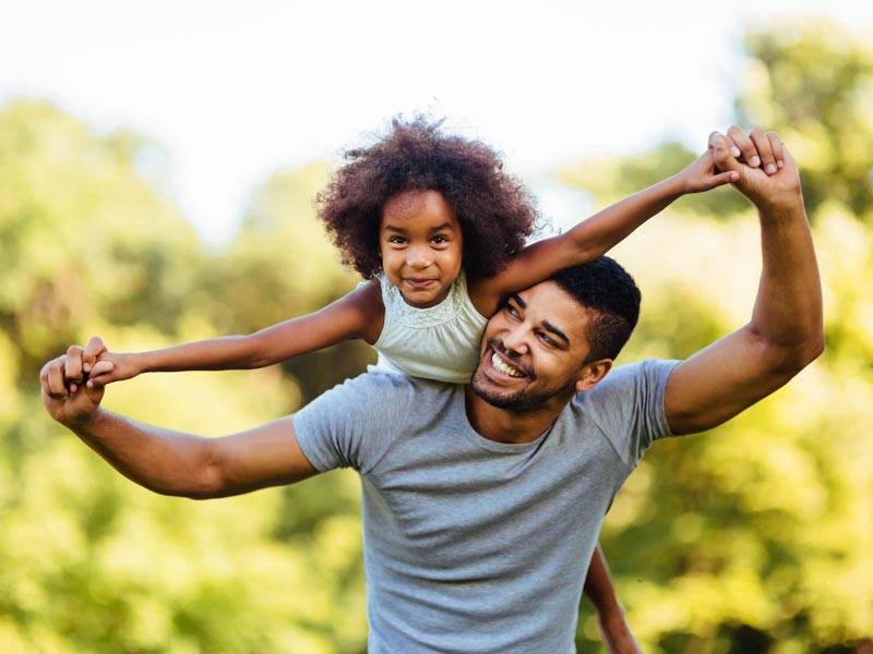 father and daughter smiling and playing