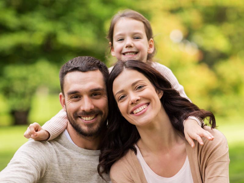 smiling family of three