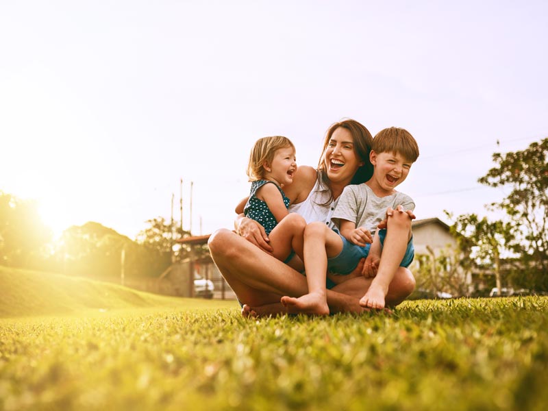 mother laughing with two young children