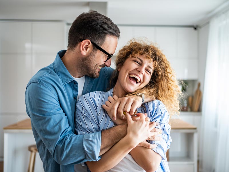 couple hugging and smiling at home