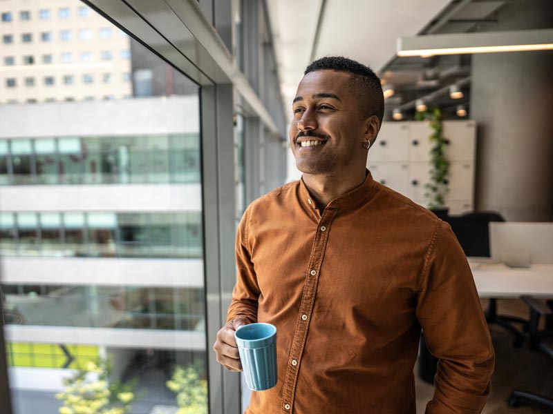 man smiling and looking out window