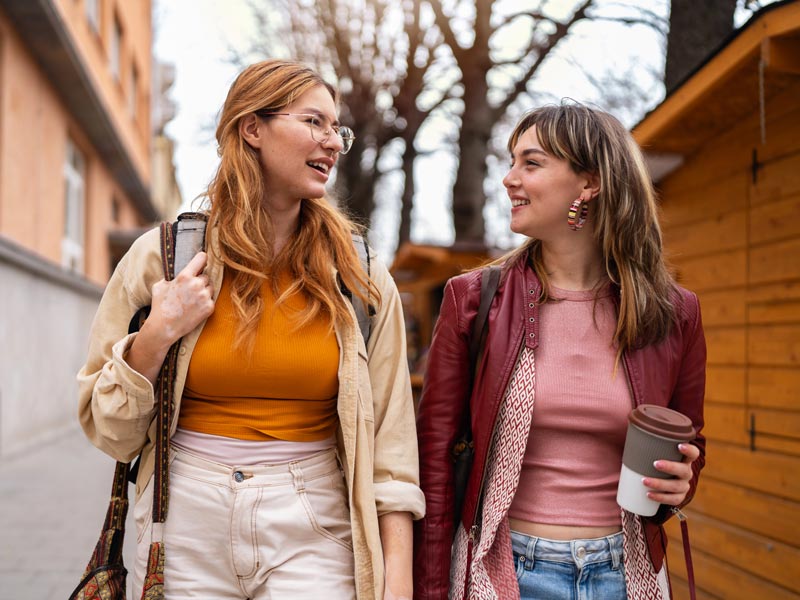 two friends walking down street