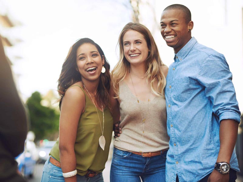 three friends smiling and posing for photo